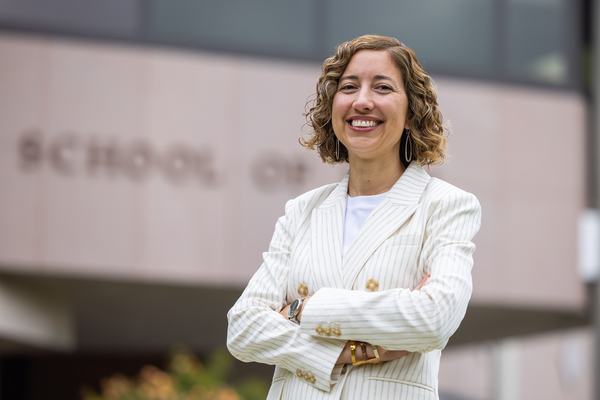 mid shot of Professor Teixeira de Sosa with crossed arms wearing an off white pin striped jacket