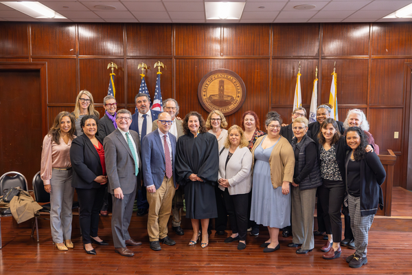 Debbie Gonzales with members of the Feinstein Clinic and RWU Law school deans with City of Central Falls seal in the background