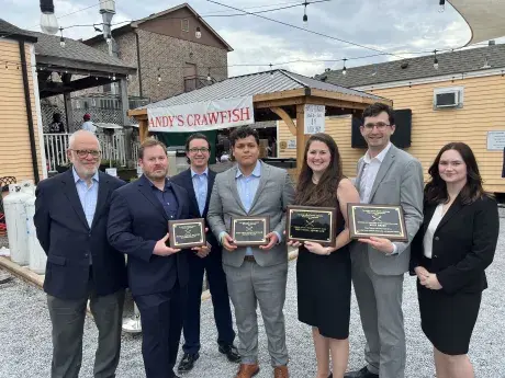 Students with Professor coaches posing outside of the competition venue