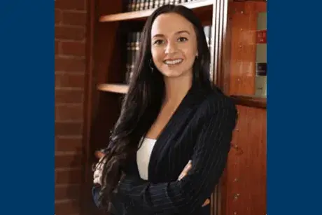 Professor Jamie Gau photo with arms crossed in front wearing a suit.