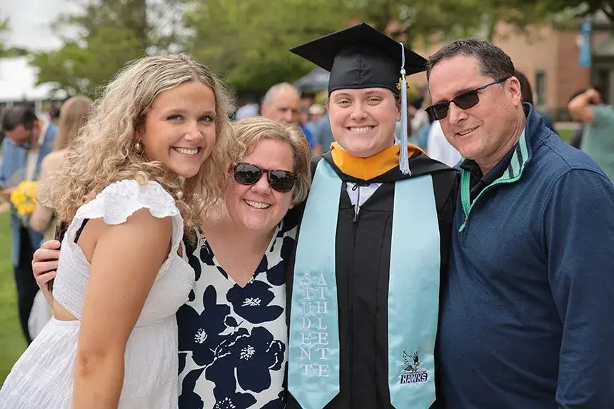An RWU gradate poses for a photo with family