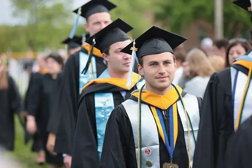 An RWU graduate walks in the procession